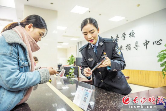 4日,在湖南省大中专学校学生信息咨询与就业指导中心大学生毕业落户专窗,民警正在向大学生介绍办理事项。 长沙晚报全媒体记者 陈飞 摄